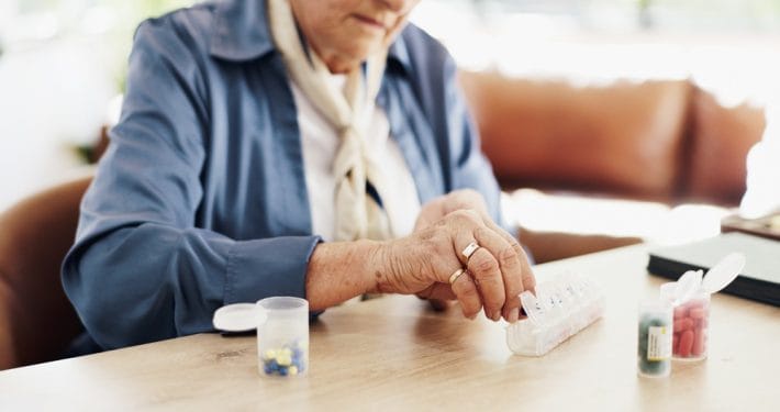 older adult prescription bottles medication organizer kitchen table senior