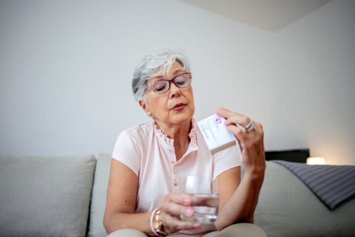 senior woman Medicare documents prescription costs calculator