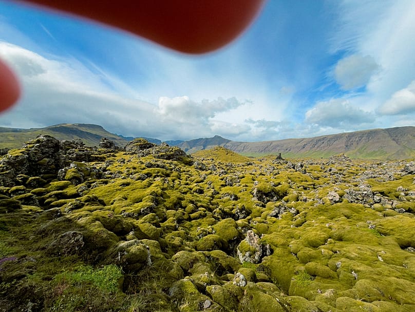 A photo of Iceland's Berserkjahraun lava field by Blanche Mortemard, featuring her fingers in the frame