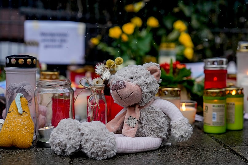 Flowers and candles and a teddy bear laid near the spot where a car drove into a group of protesters in Munich, 16 February, 2025