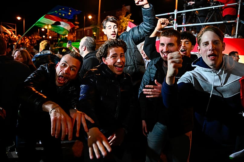 People celebrate in the streets following the announcement of the partial results of the parliamentary election in Budapest, 12 April, 2026