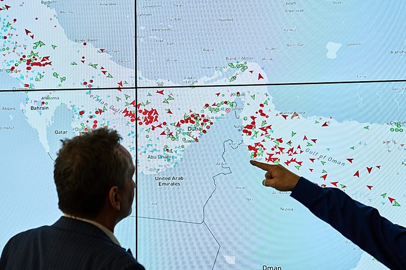 Hapag-Lloyd employees monitor the status of cargo ships in the Strait of Hormuz on a screen in Hamburg, 15 April, 2026