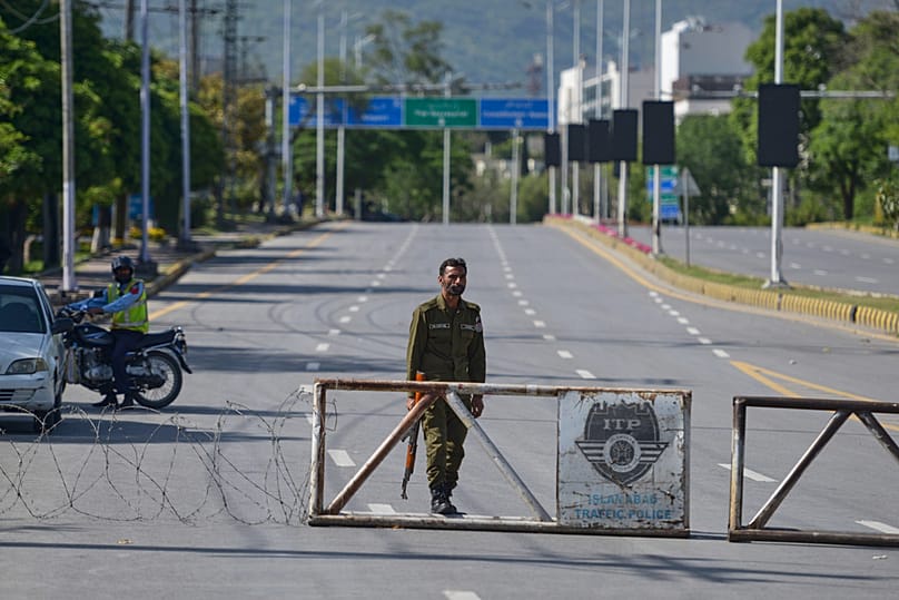 A police officer stands guard at a checkpoint on a barricaded road to ensure security ahead of the second round of US-Iran talks, Islamabad, Pakistan, Sunday, April 19, 2026