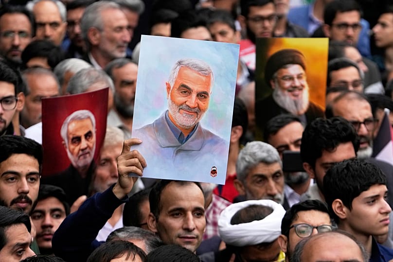 FILE - Demonstrators hold up posters of the late IRGC commander Qasem Soleimani during an annual rally in front of the former US Embassy in Tehran, 3 November 2024