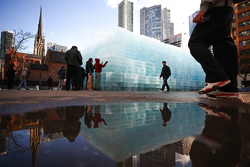 People gather around blocks of ice, installed in a Toronto parking lot as part of promotion for rapper Drake's upcoming album 'ICEMAN'