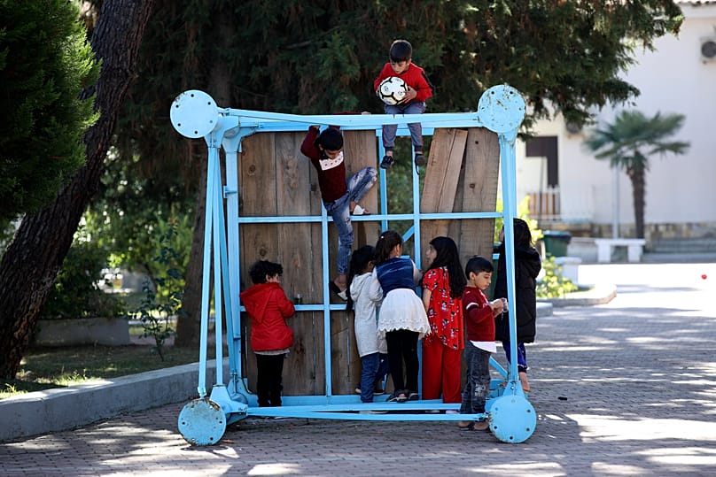 Children play at a coastline tourist resort in Golem, 27 October, 2021