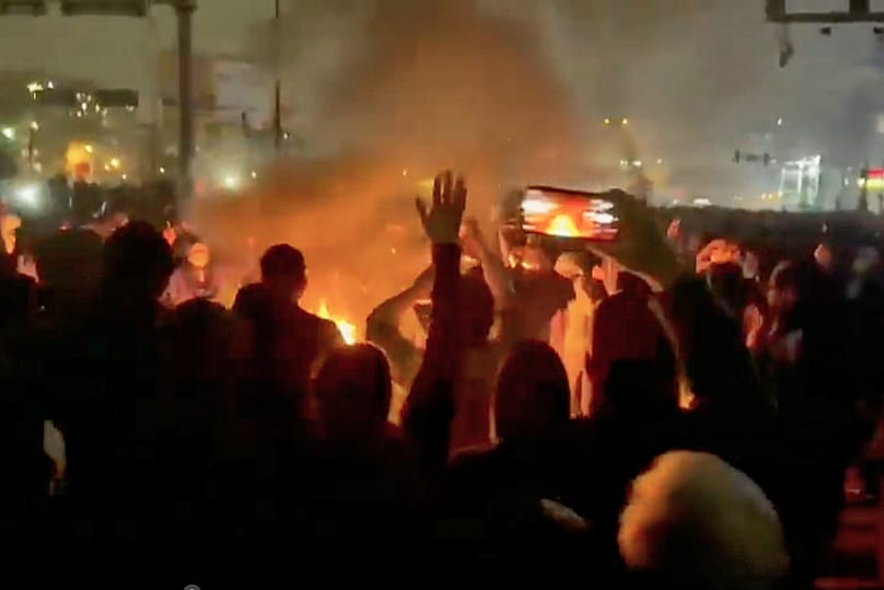 FILE: In this image from video circulating on social media, protesters dance and cheer around a bonfire as they take to the streets of Tehran, 9 January 2026