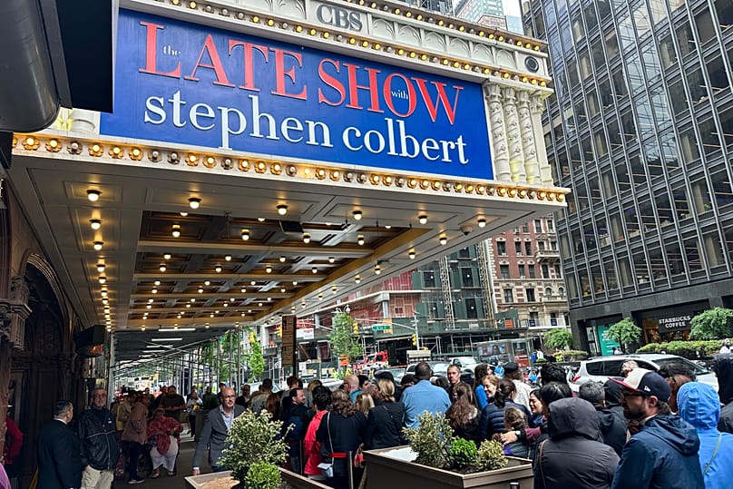 Fans line up in the rain outside the Ed Sullivan Theater in New York on Thursday 21 May, ahead of the final episode of The Late Show with Stephen Colbert