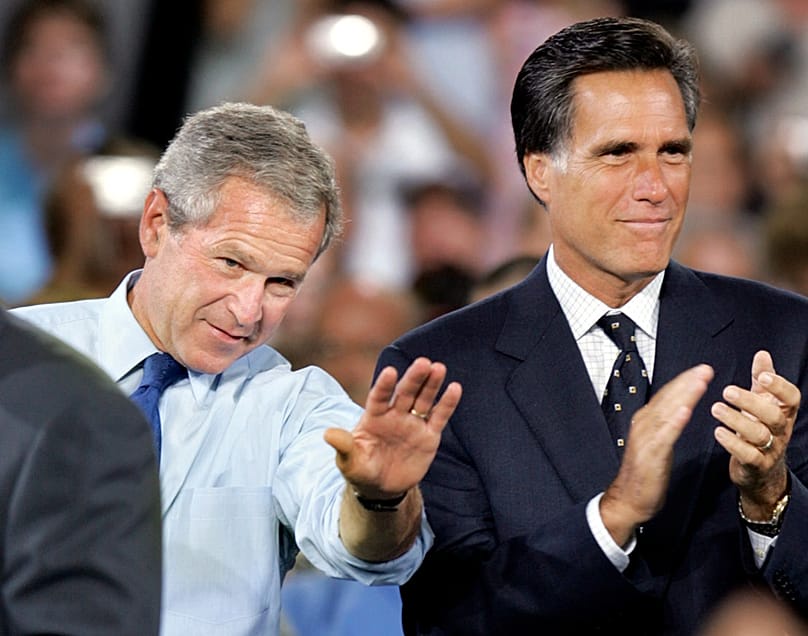 US President George W. Bush waves as Massachusetts Gov. Mitt Romney applauds at a campaign event in Nashua, New Hampshire, Aug. 30, 2004  (AP Photo/Steven Senne, File)