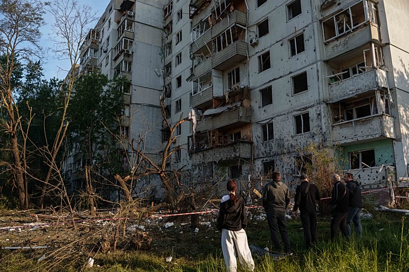 People look at a residential apartment building damaged after a Russian strike on Kyiv, 2 June, 2026