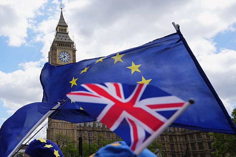 Pro-EU campaigners hold flags near parliament in London, 20 May, 2026