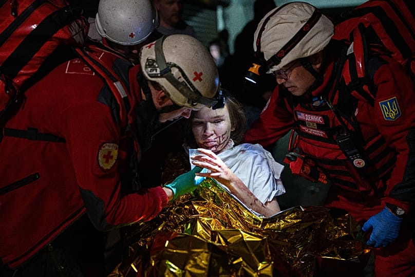 Red Cross volunteers help an injured woman in a shelter after a Russian strike on a residential neighborhood in Kyiv, Ukraine, on Sunday, May 24, 2026.