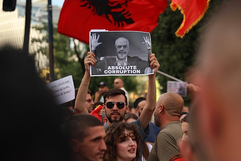 Protesters with a poster depicting Prime Minister Edi Rama take part in a rally in Tirana, 6 June, 2026 