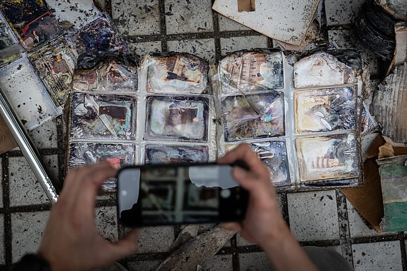 A man takes pictures of a charred family album found at their flat at Wang Fuk Court in Hong Kong, 20 April, 2026
