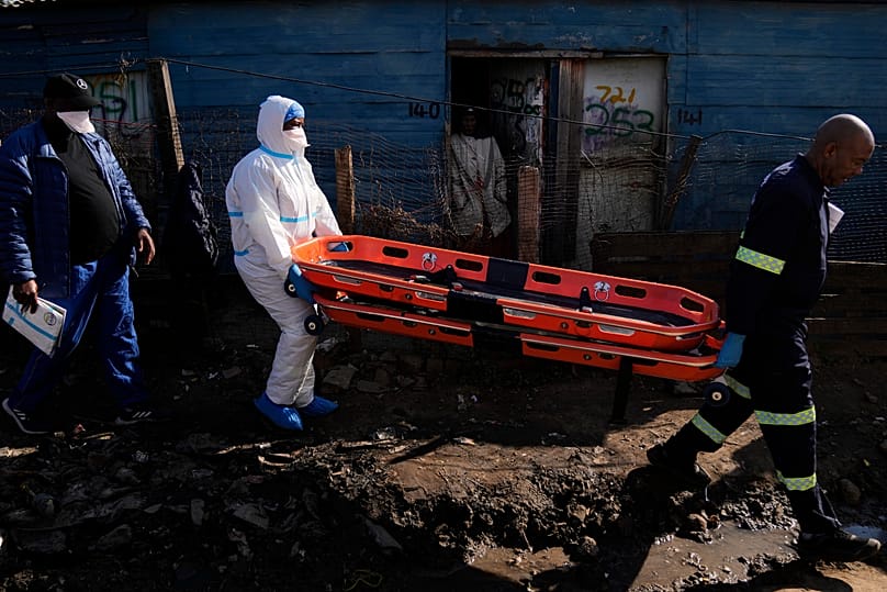 Police officers carry stretchers after a mass shooting at an informal settlement near Johannesburg, 10 June, 2026
