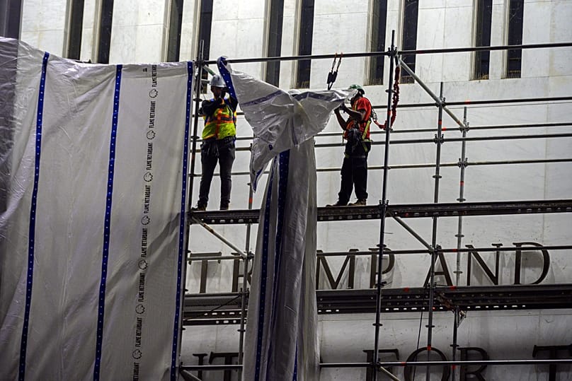 Workers install tarps on the scaffolding at the John F. Kennedy Center - Saturday 13 June 2026