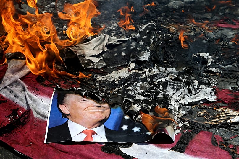 A poster of US President Donald Trump is set on fire during a rally in Tehran, 8 June, 2018