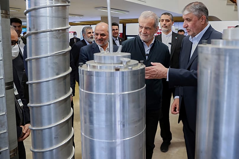 FILE - President Masoud Pezeshkian listens to head of Atomic Energy Organization of Iran as he visits an exhibition of Iran's nuclear sector, in Tehran, Iran, April 9, 2025