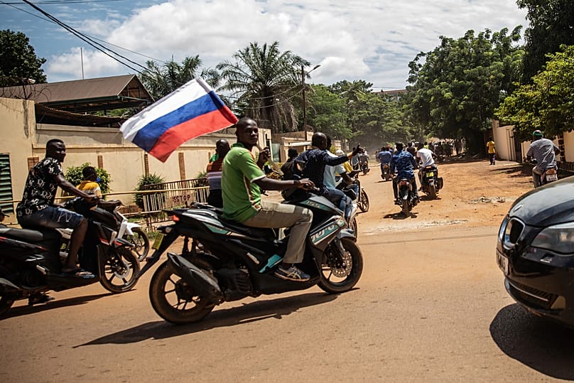 FILE: Supporters of Captain Ibrahim Traore parade wave a Russian flag in the streets of Ouagadougou, Burkina Faso, 2 October 2022
