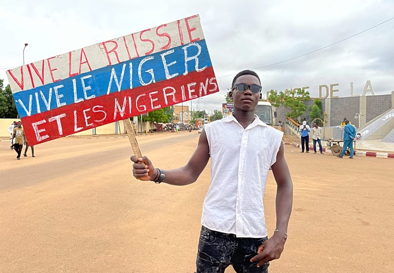 FILE: A supporter of Niger's ruling junta holds a placard in the colours of the Russian flag at the start of a protest in Niamey, Niger, 3 August 2023