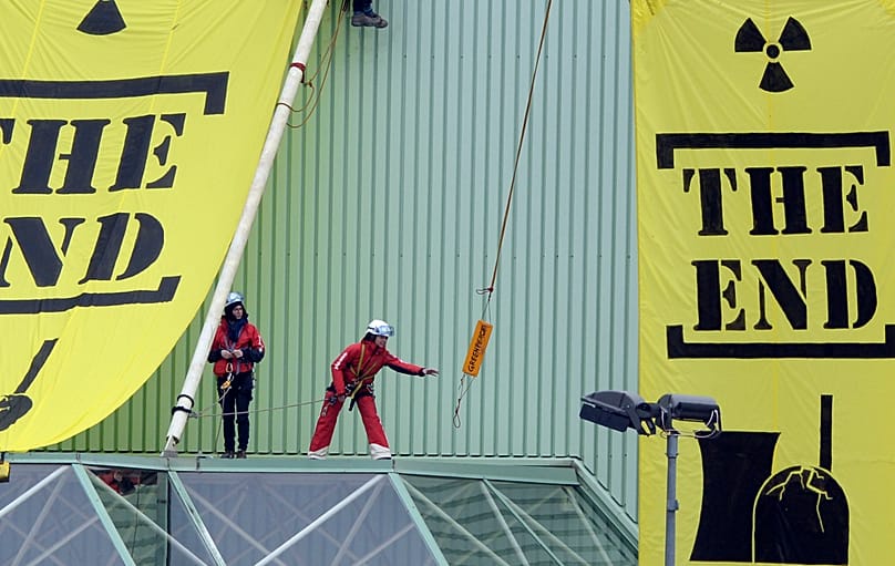 Greenpeace activists hang banners saying 