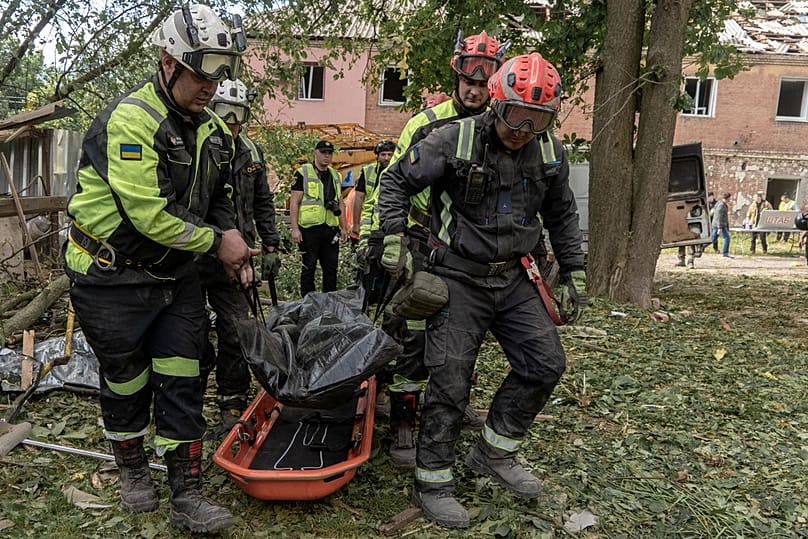 Rescuers carry a body that they removed from under the rubble of an apartment building following Russia's missile attack in Kharkiv, Ukraine, Saturday, June 20, 2026. (AP Phot