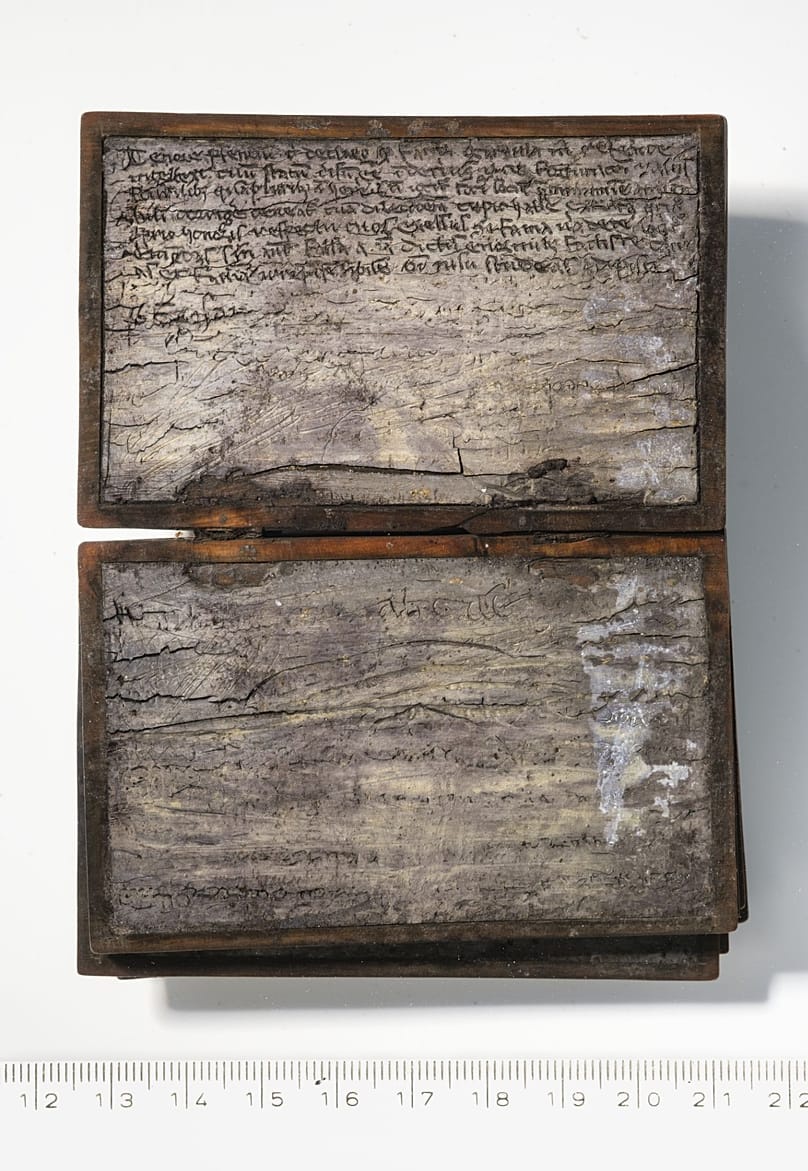 The Latin inscription engraved in the wax is clearly visible.