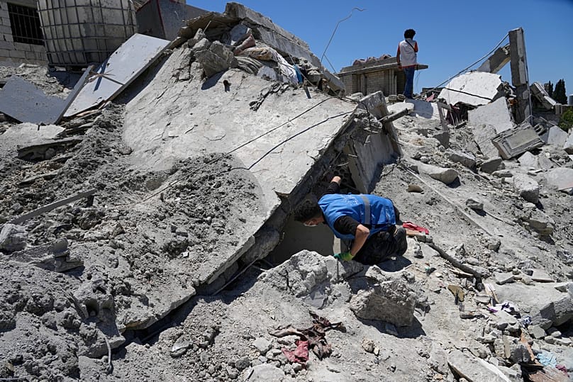 A rescue worker searches for victims under the rubble of a destroyed building that was hit in an Israeli airstrike in Qannarit village, southern Lebanon, June 20, 2026.