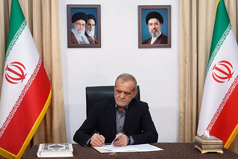 Iranian President Masoud Pezeshkian signs a framework deal already signed by U.S. President Donald Trump, launching negotiations on a broader agreement, in Tehran, 18 May 2026
