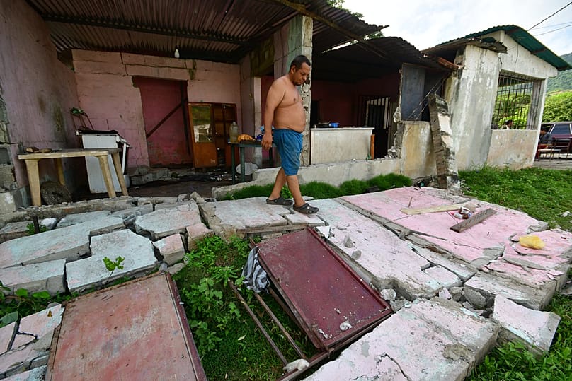 A man walks over the fallen walls of his home in Moron, near the epicenter of two earthquakes that struck Venezuela the day before, Thursday, June 25, 2026