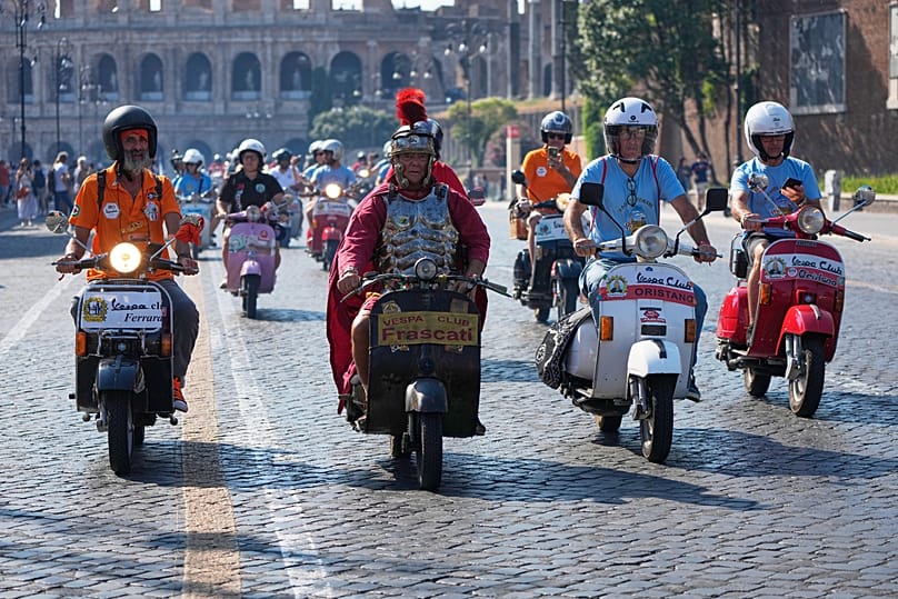 Vespa enthusiasts ride in a parade during celebrations for the 80th anniversary of the Vespa scooter, in Rome, Saturday 27 June 2026. (AP Photo/Alessandra Tarantino)