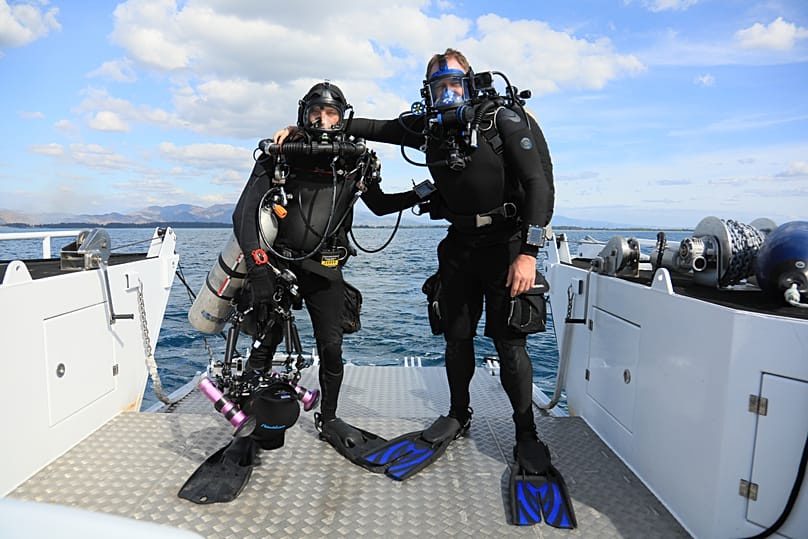 Explorer Josh Gates and diver Evan Kovacs beside the wreck of the Hōfuku Maru.