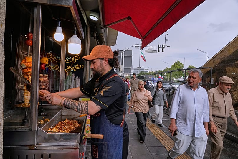 A street vendor slices doner kebab at a food stall in downtown Tehran, Iran 