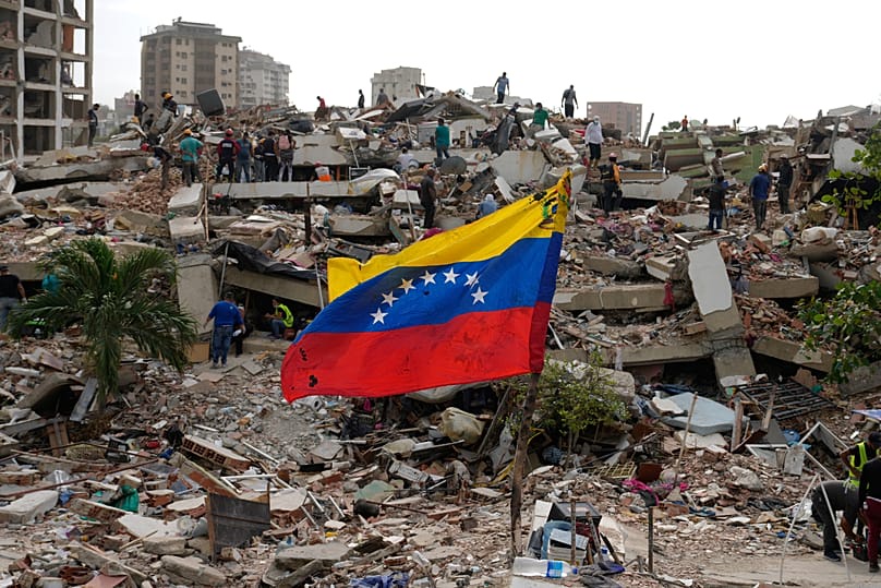 Residents and rescue workers search through the rubble of buildings damaged in the earthquakes that struck La Guaira, Venezuela, Thursday, July 2, 2026