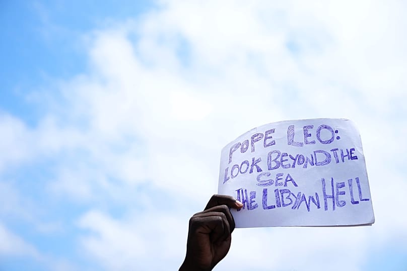 A sign urges the Pope to look beyond the sea, towards the 'hell in Libya'