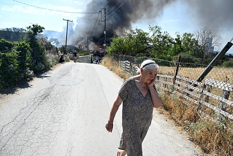 A woman reacts during a wildfire on the outskirts of the northern city of Thessaloniki, 5 July, 2026