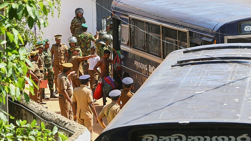 Security personnel escort prisoners to a bus in the compound of Negombo prison, 6 July, 2026