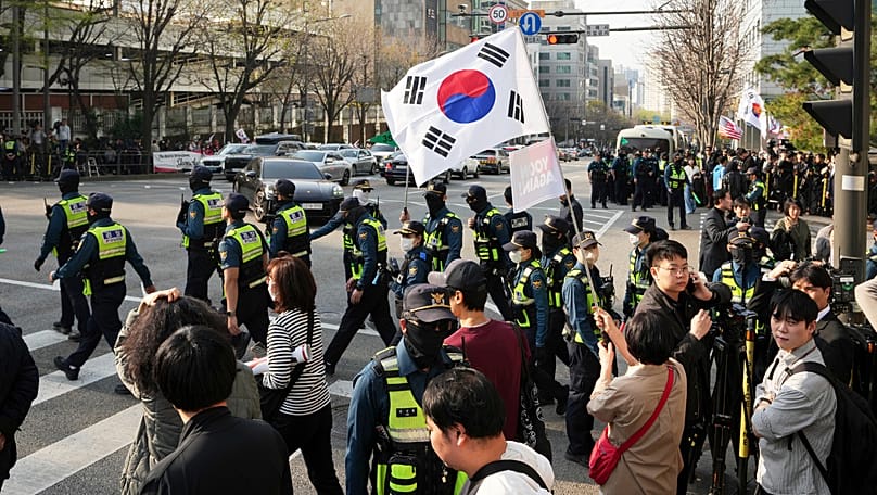 Supporters of former South Korean President Yoon Suk Yeol gather as police officers arrive near the private residence in Seoul, 11 April, 2025