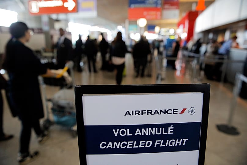 APA traveller walks past a board reading 