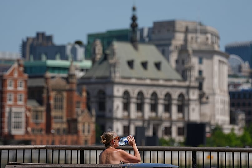 A woman takes a drink in London as a heatwave is predicted, 23 June, 2026