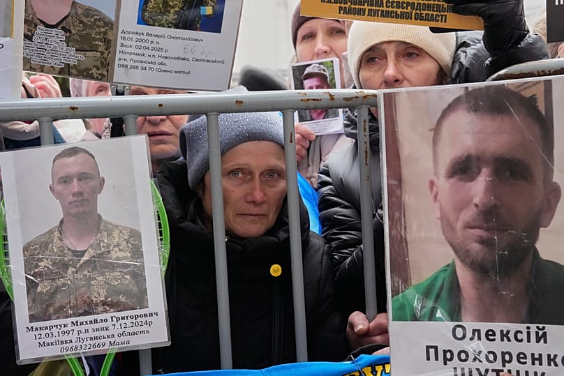 People hold photos of their relatives as Ukrainian soldiers return from captivity during a POW exchange in Chernyhiv region, 11 April, 2026