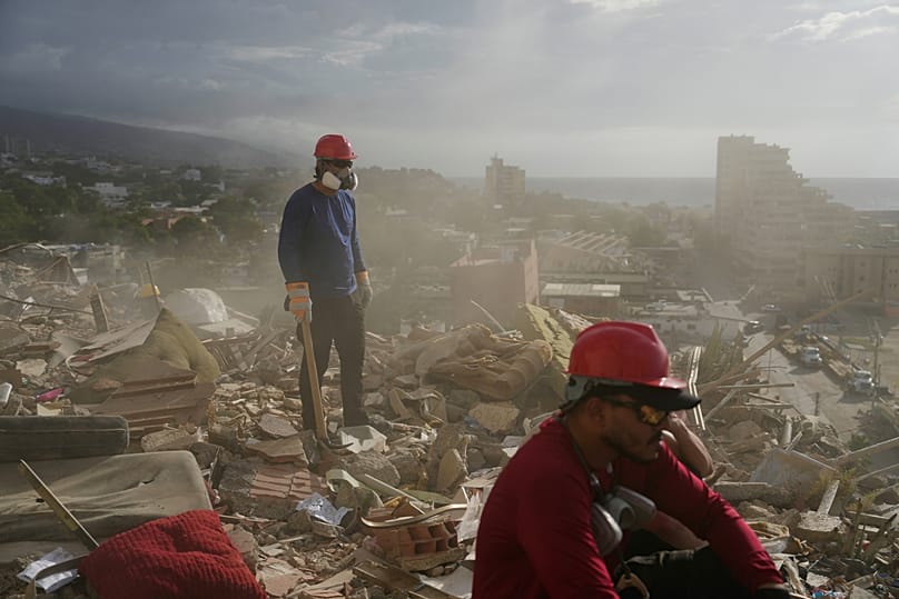 Rescue workers and volunteers search through the rubble of a building collapsed during the earthquakes in La Guaira, Venezuela