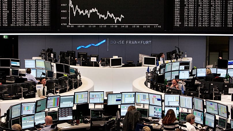 Brokers are seen under the curve of German stock index DAX at the stock market in Frankfurt, central Germany, Monday, Oct. 20, 2008.