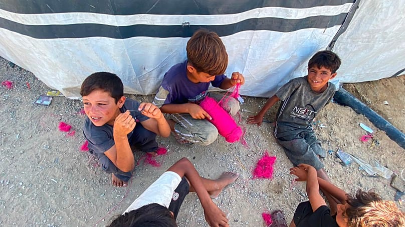 Palestinian children playing outside a displaced family's tent in the Gaza Strip