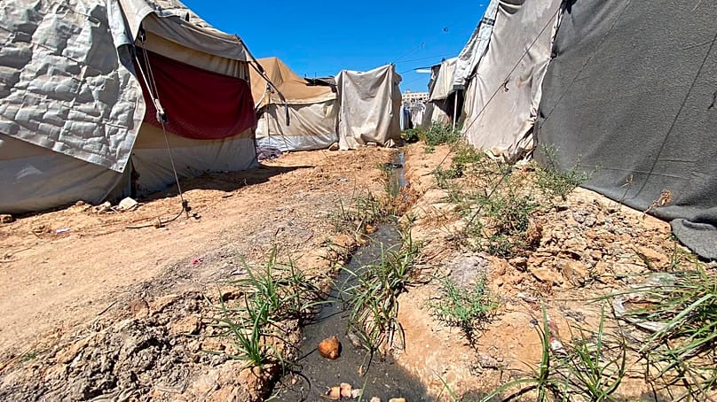 Sewage water running between displaced families' tents in central Gaza Strip