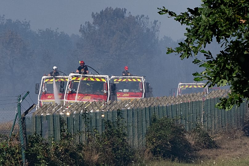 Firefighters work near the scene where two firefighters died while battling a building fire in Merignac, southwestern France, Tuesday, July 21, 2026.