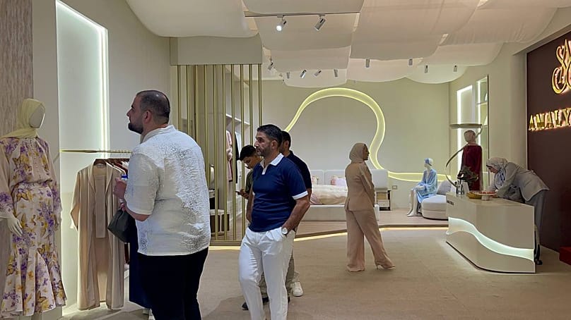 Visitors in a showroom dedicated to clothing at the Nas Tex 2026 exhibition at the Damascus fairgrounds