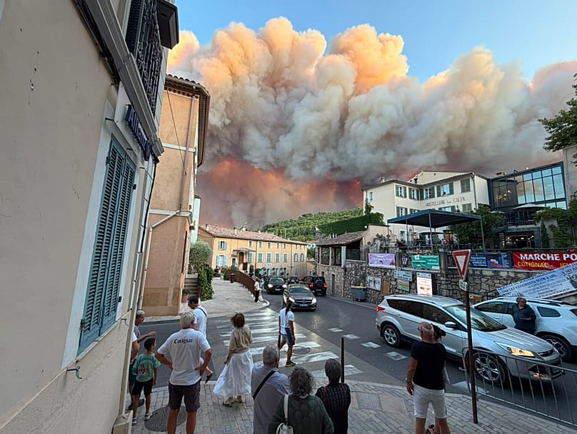 Residents look on as smoke and fire approach the village of Pontignac, in Provence, south of France, 21 July 2026