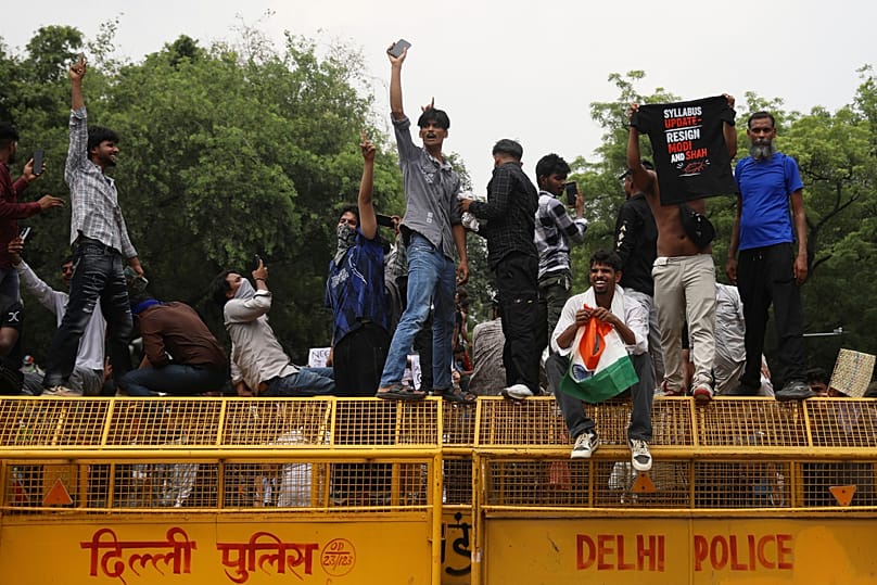 Protesters react after India's education minister Dharmendra Pradhan resigned following nationwide 