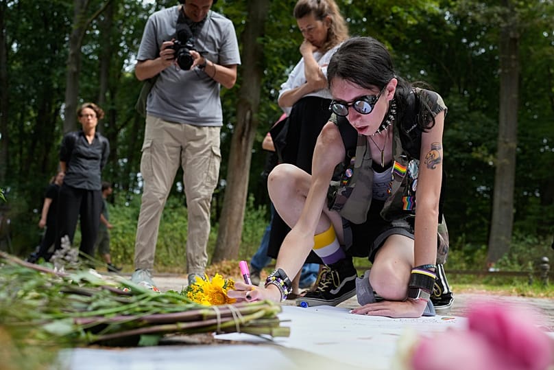 Ashley Schreiber lays flowers near the scene of the attack; a car had ploughed into the crowd at Berlin's CSD, killing one woman and injuring 29 people  (c) AP